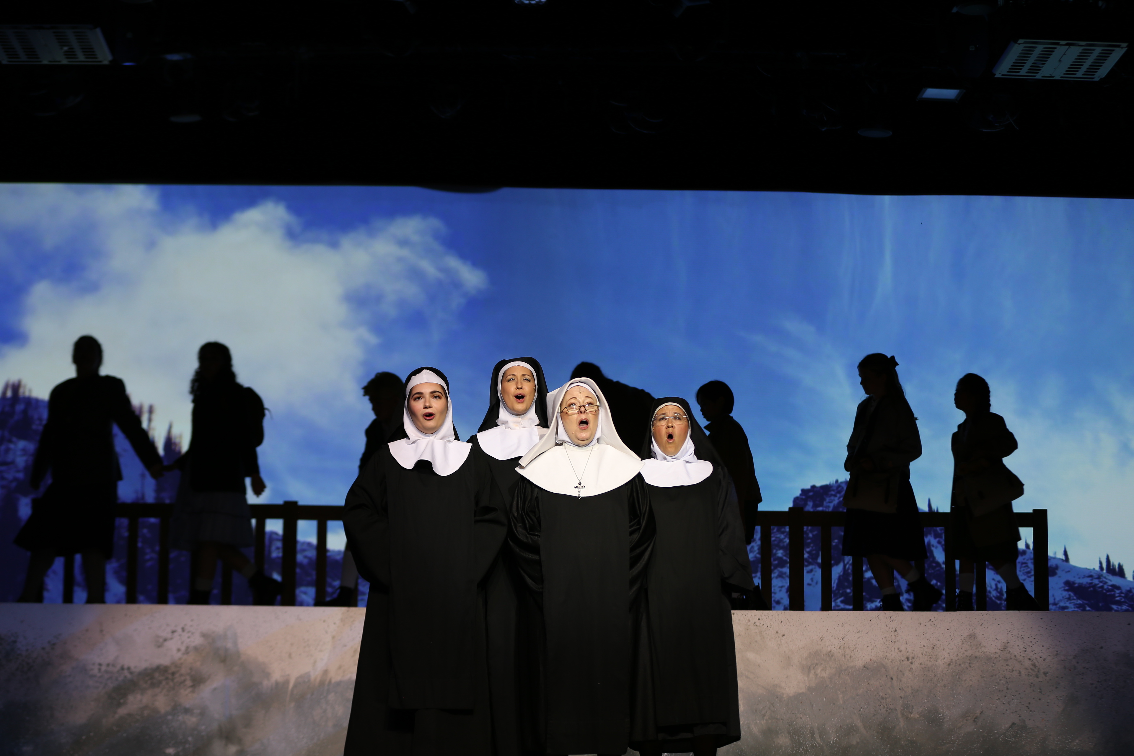 nuns singing with children in background